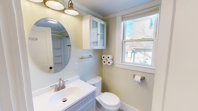 bathroom featuring vanity, toilet, walk in shower, and crown molding