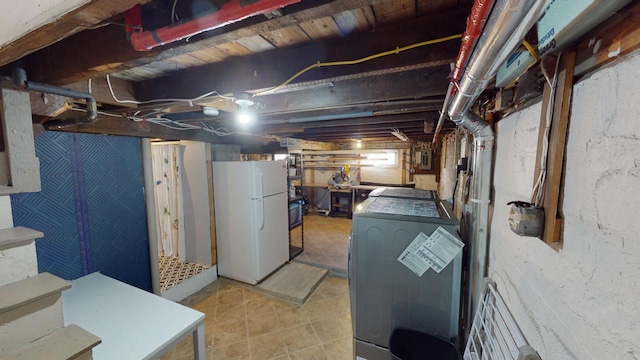 basement featuring washer / clothes dryer and white refrigerator