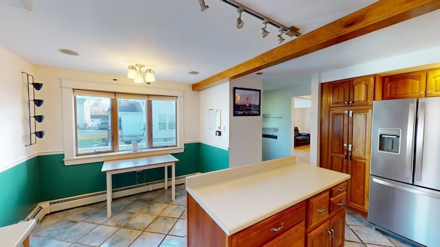 kitchen featuring stainless steel refrigerator with ice dispenser, track lighting, a baseboard heating unit, beamed ceiling, and a kitchen island