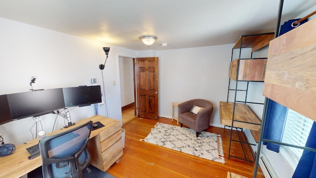 office space featuring baseboard heating and light hardwood / wood-style flooring