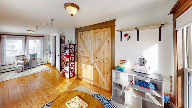 interior space with a baseboard radiator and hardwood / wood-style flooring