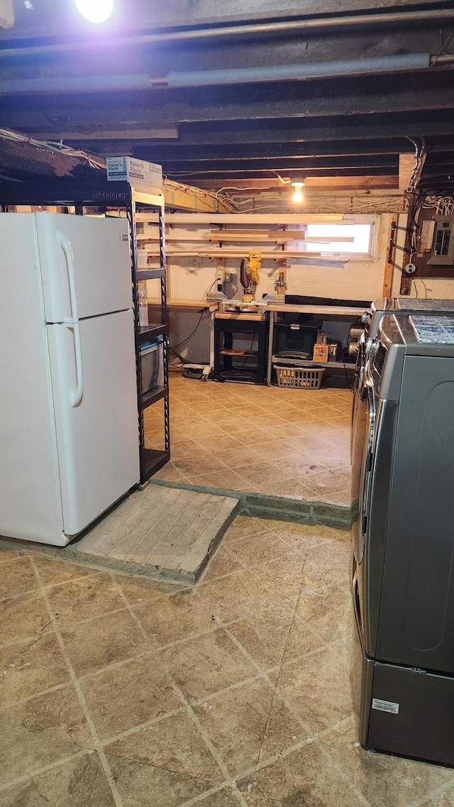 basement featuring white refrigerator and washing machine and clothes dryer