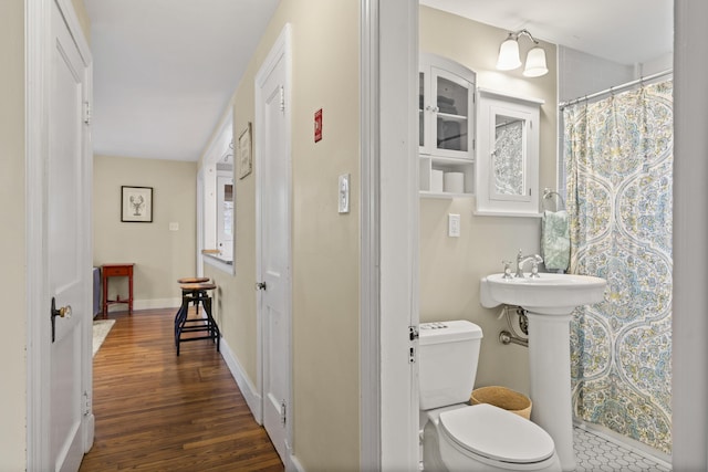 bathroom featuring wood-type flooring, toilet, and walk in shower