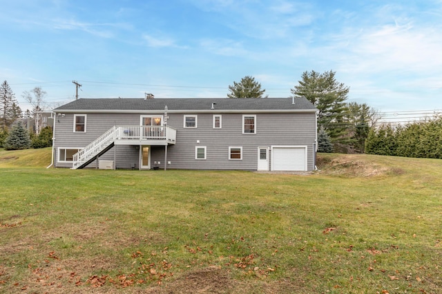 rear view of property with a yard, a garage, and a deck