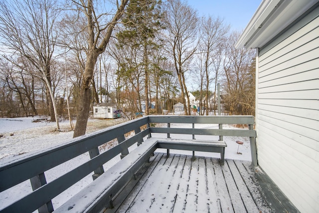 snow covered deck featuring a storage unit