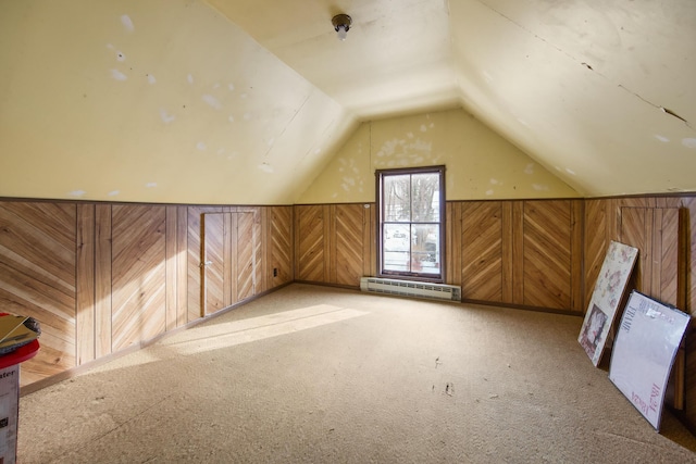 additional living space with wood walls, light colored carpet, lofted ceiling, and a baseboard heating unit