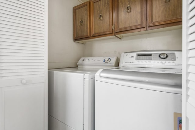 washroom featuring cabinets and independent washer and dryer