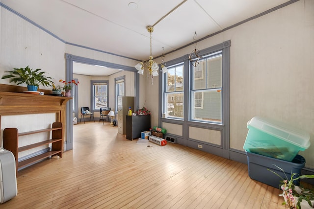 miscellaneous room with an inviting chandelier and light wood-type flooring