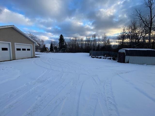 yard covered in snow with an outbuilding