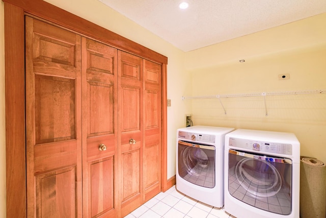 laundry area featuring light tile patterned floors, a textured ceiling, and independent washer and dryer