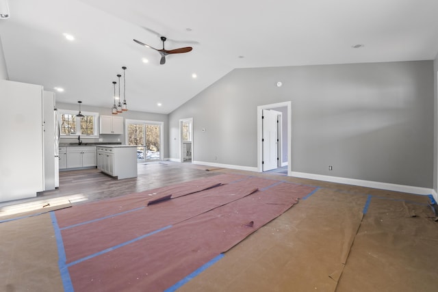 unfurnished living room featuring ceiling fan, lofted ceiling, and sink