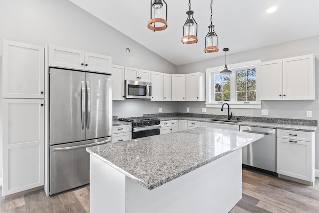 kitchen featuring white cabinets, a kitchen island, hanging light fixtures, and appliances with stainless steel finishes