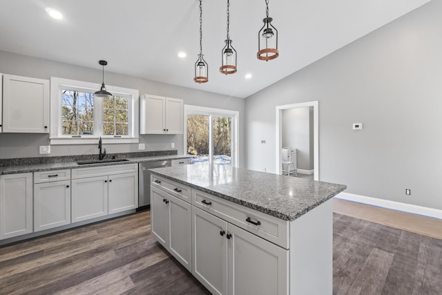 kitchen with white cabinets, sink, hanging light fixtures, vaulted ceiling, and stainless steel dishwasher