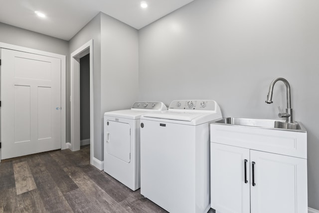 clothes washing area featuring washer and dryer, dark hardwood / wood-style floors, and sink