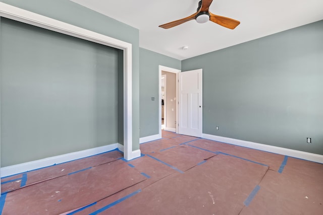 unfurnished bedroom with ceiling fan and a closet