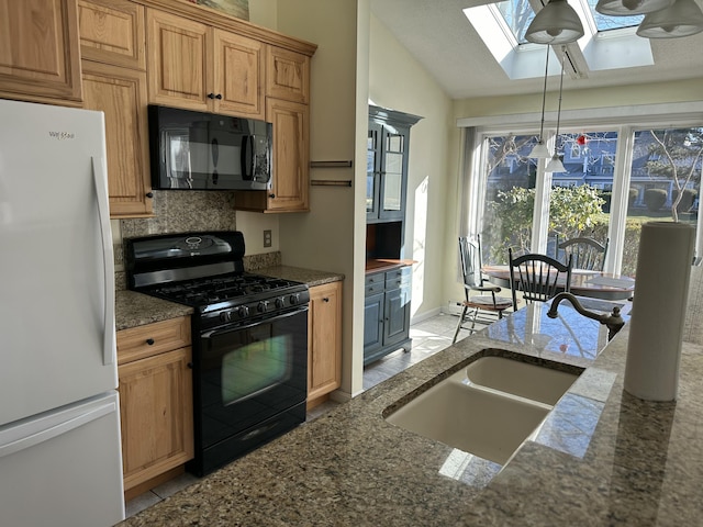 kitchen featuring sink, dark stone countertops, decorative backsplash, vaulted ceiling with skylight, and black appliances