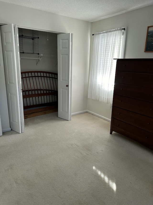 unfurnished bedroom with a textured ceiling and light carpet