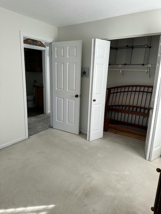 unfurnished bedroom with a textured ceiling and light carpet