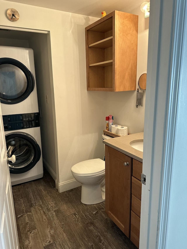 bathroom with vanity, toilet, wood-type flooring, and stacked washer / dryer