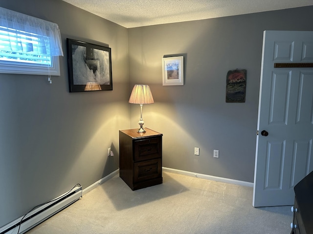 interior space with a textured ceiling and a baseboard heating unit