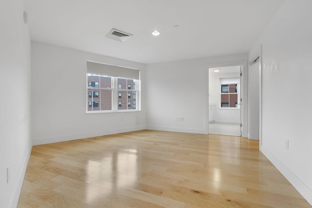 empty room with plenty of natural light and light hardwood / wood-style floors