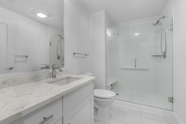 bathroom with tile patterned floors, a shower with door, vanity, and toilet