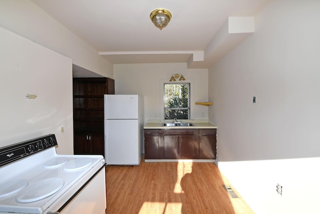 kitchen featuring light hardwood / wood-style floors, white appliances, and sink