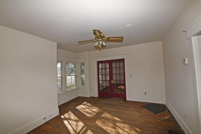 empty room with french doors, ceiling fan, and dark wood-type flooring