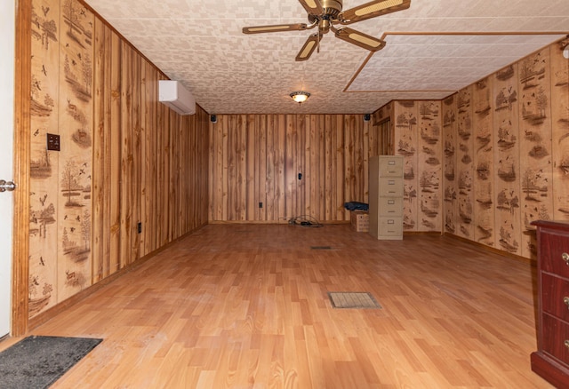 basement featuring wood-type flooring, a wall unit AC, and wooden walls