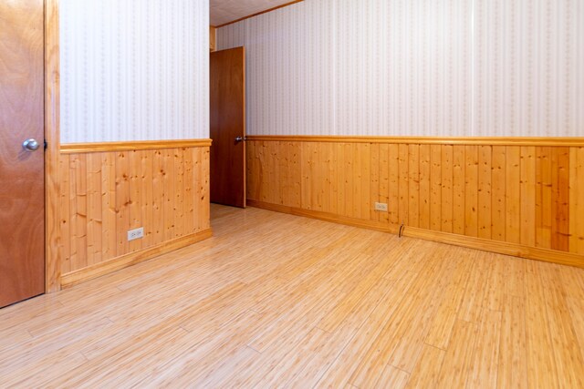 empty room featuring light hardwood / wood-style floors and wood walls