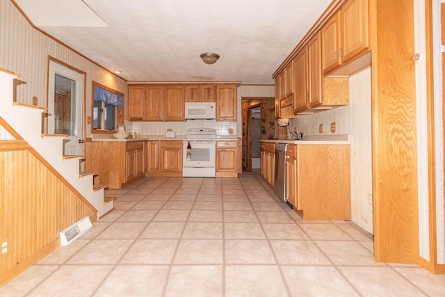 kitchen featuring light tile patterned floors, white appliances, and tasteful backsplash