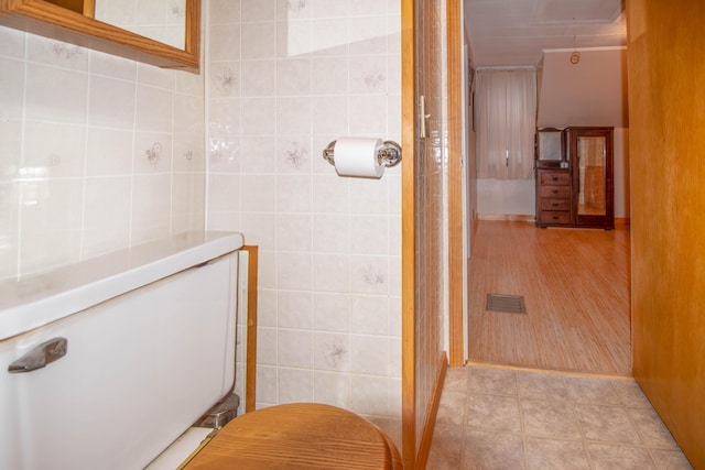 bathroom featuring tile patterned flooring and tile walls