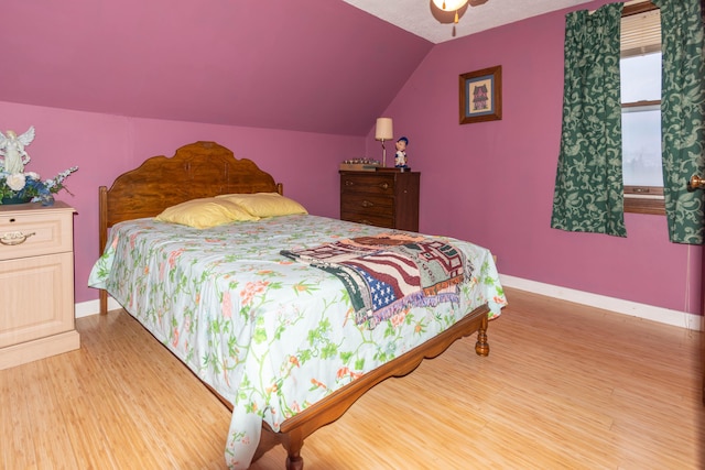 bedroom featuring hardwood / wood-style flooring, vaulted ceiling, and ceiling fan