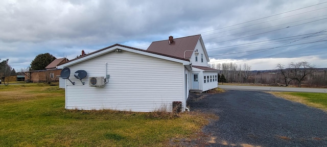 view of side of property featuring a lawn and ac unit