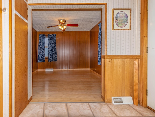 hall with wooden walls and hardwood / wood-style floors