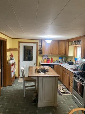 kitchen featuring a breakfast bar, a kitchen island, and stainless steel range with gas stovetop