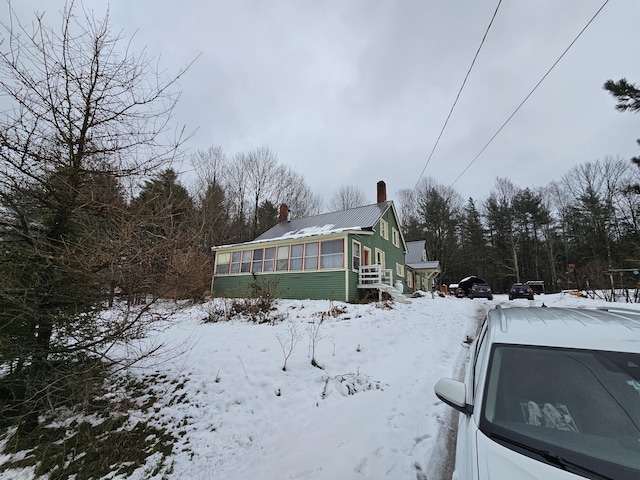 snow covered property with a sunroom