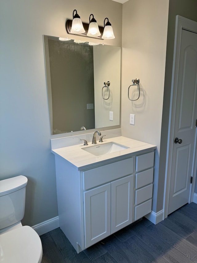 bathroom with vanity, wood-type flooring, and toilet