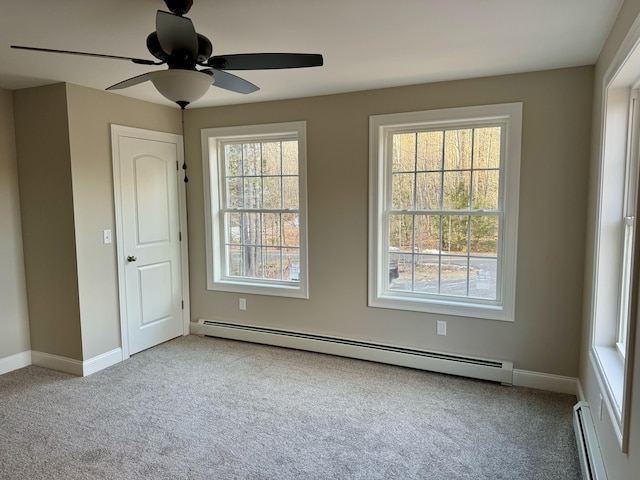 carpeted empty room with ceiling fan and a baseboard radiator