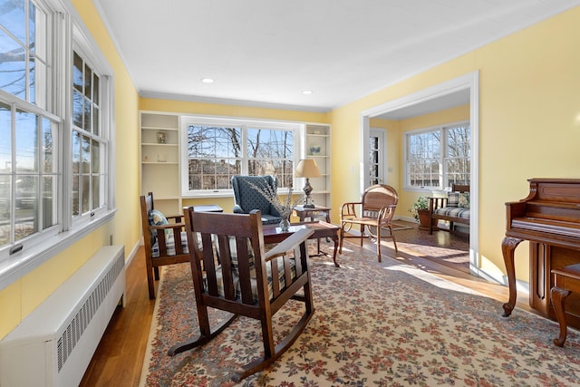 sitting room featuring radiator heating unit and hardwood / wood-style floors