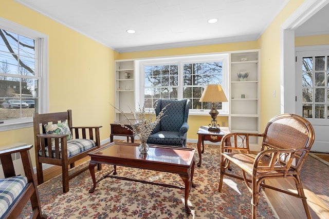 living area featuring ornamental molding, a healthy amount of sunlight, and hardwood / wood-style flooring