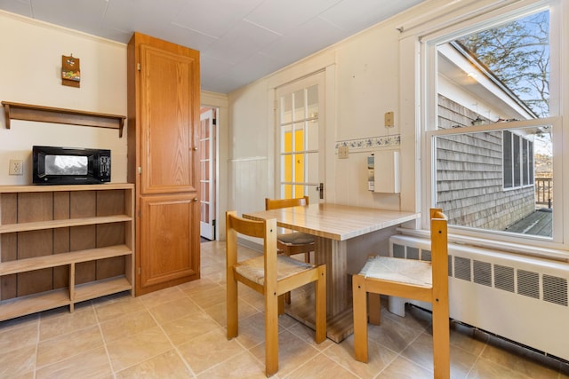 dining room with radiator, a wealth of natural light, and crown molding