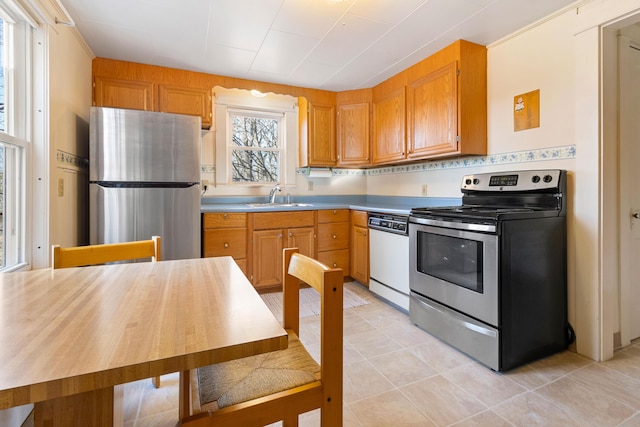 kitchen with sink, light tile patterned floors, and stainless steel appliances