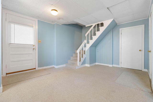 basement featuring a paneled ceiling and carpet floors