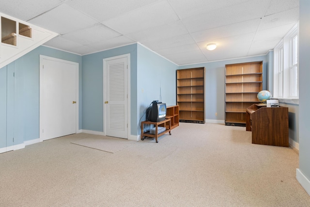 interior space with a paneled ceiling and crown molding