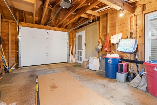 garage featuring wood walls and a garage door opener