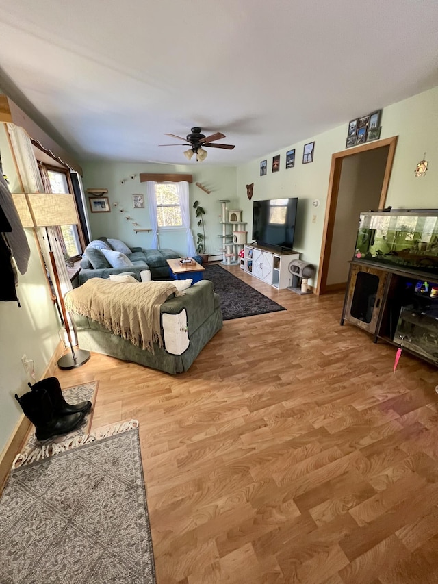 living room with wood-type flooring, vaulted ceiling, and ceiling fan