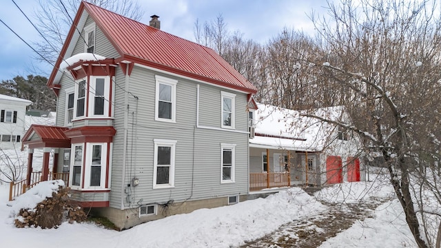 snow covered property featuring covered porch