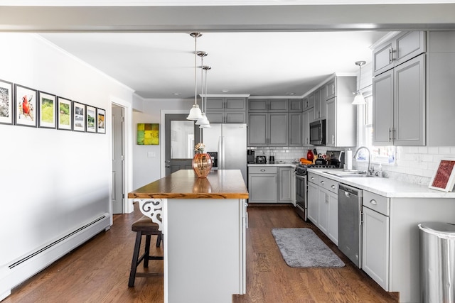 kitchen featuring appliances with stainless steel finishes, a kitchen island, baseboard heating, and gray cabinetry