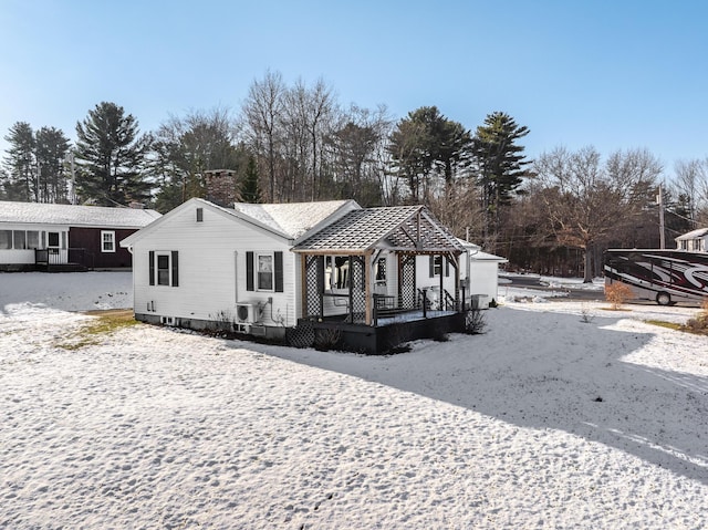 view of front facade with covered porch and central AC